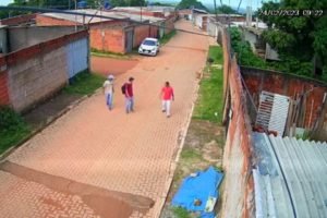 Homens andando em rua de casas