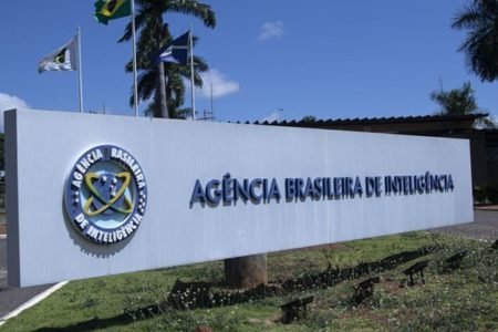 Fotografia colorida mostra placa grande com nome Agência Brasileira de Inteligência