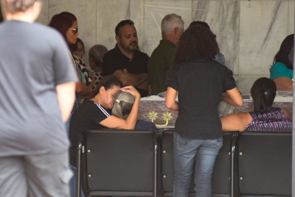 Pessoas choram ao lado de caixão de vítima de feminicídio