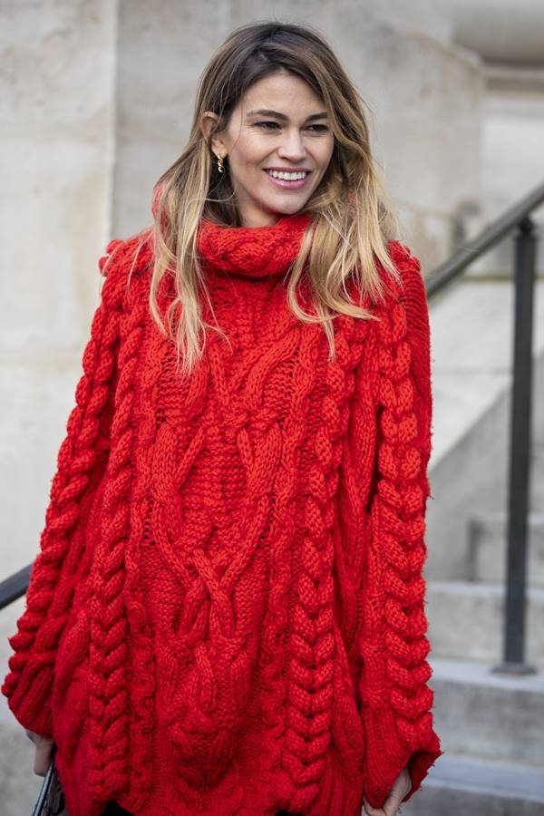 Mulher loira usa tricô vermelho de gola alta- Metrópoles