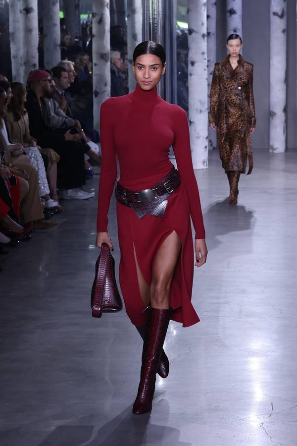 Na passarela, modelo usa vestido vermelho de golta alta com cinto preto - Metrópoles