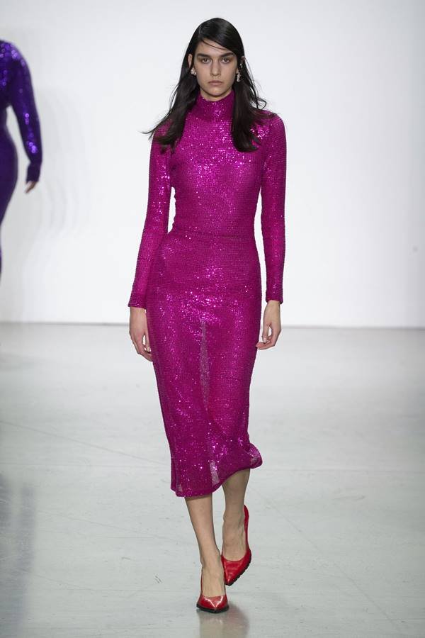 Na passarela, modelo usa vestido rosa brilhante com gola alta - Metrópoles
