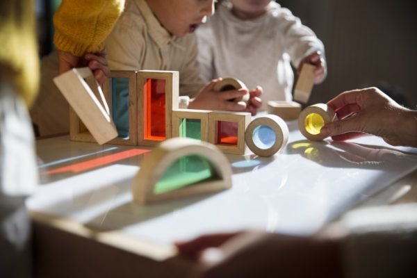 Imagem mostra crianças brincando com peças de montar coloridas - Metrópoles
