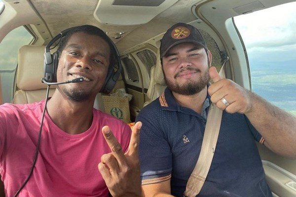 Fotografia colorida de dois homens dentro de avião