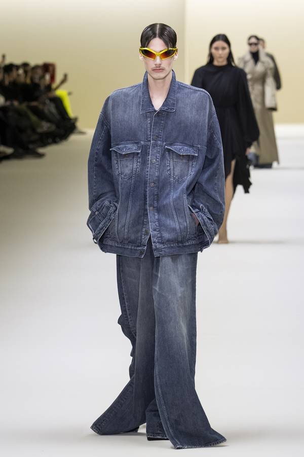 Modelo da Balenciaga usa calça jeans ampla, jaqueta e óculos escuro - Metrópoles
