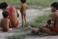 Foto colorida mostra crianças e adulto da etnia Yanomami - Metrópoles