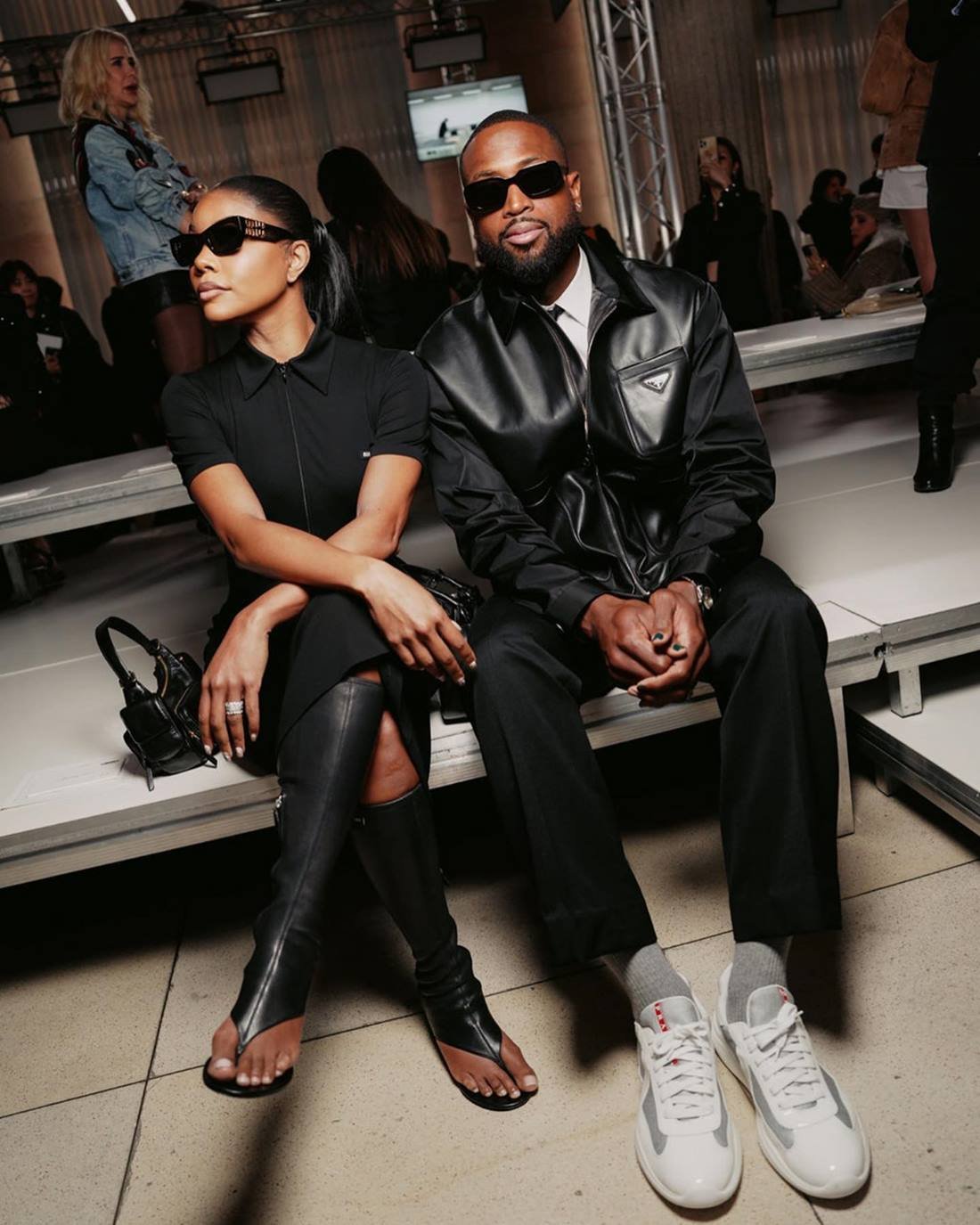 A atriz Gabrielle Union e o marido, o jogador de basquete, Dwayne Wade, no desfile da Miu Miu na Semana de Moda de Paris. Os dois são negros e de meia idade e usam roupas pretas e óculos escuros. - Metrópoles