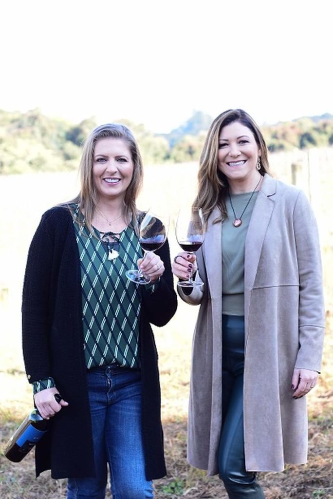 Na foto, duas mulheres segurando taças de vinho - Metrópoles