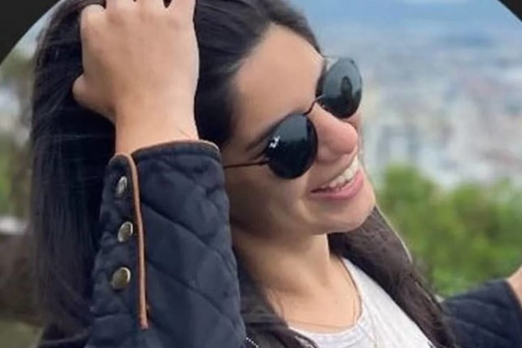 mulher sorri passando a mão no cabelo - metrópoles