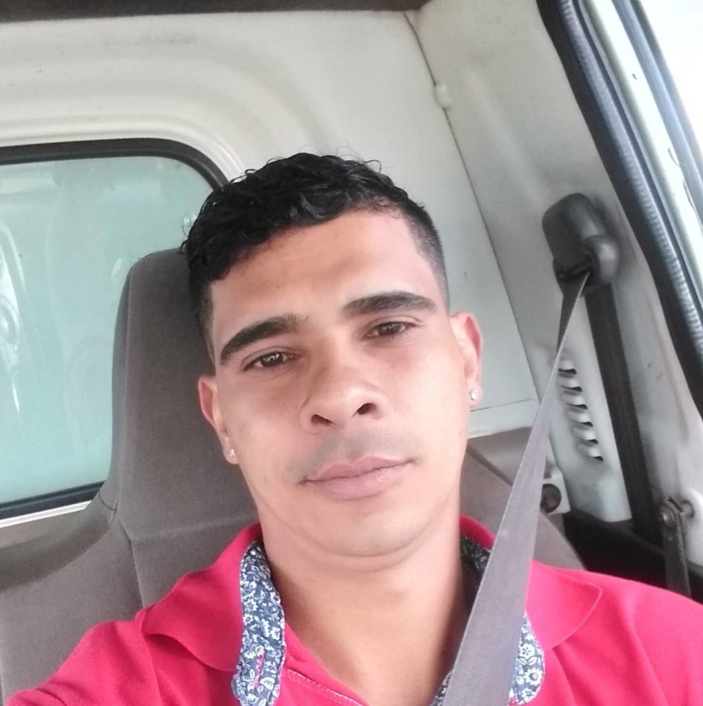 Homem dentro de carro vestido de vermelho