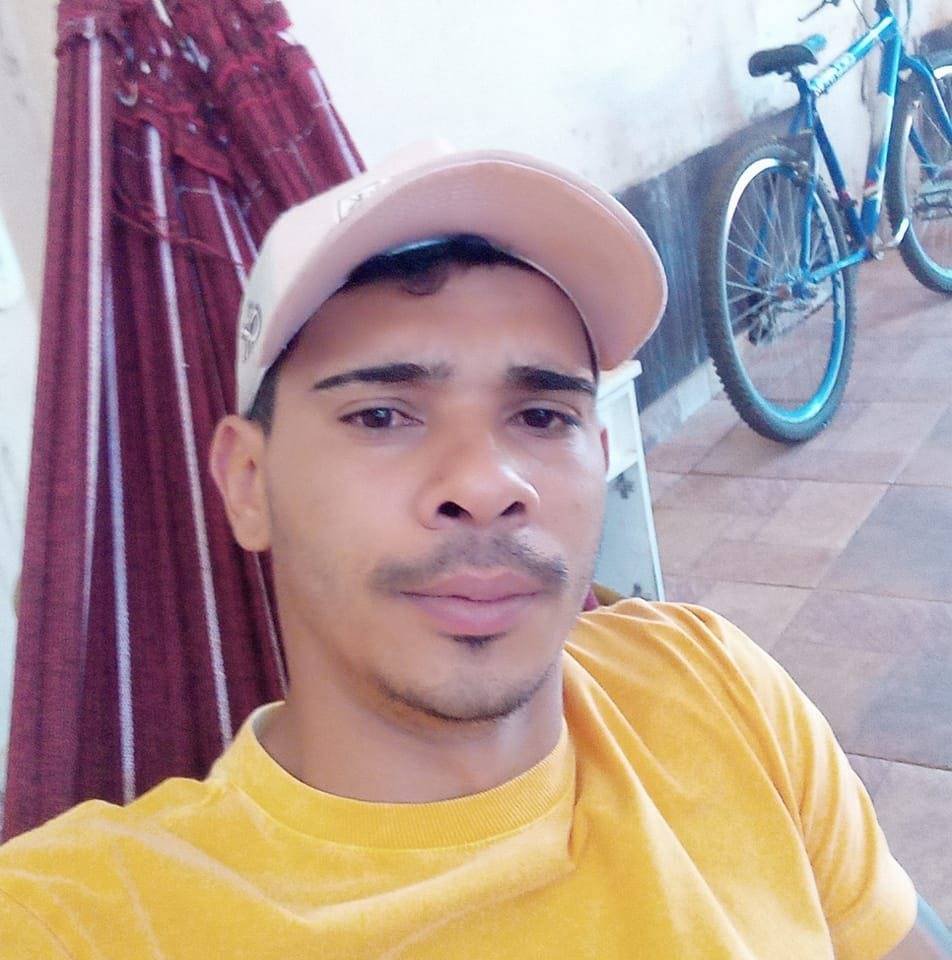 Homem em rede de boné e camisa amarela