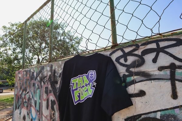 Camiseta da marca Tha F*ck pendurada em cabide em quadra de esportes - Metrópoles