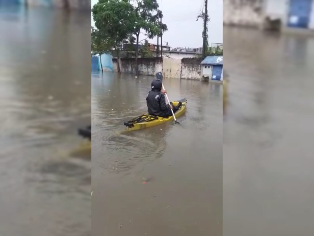 Morador usa caiaque para andar em rua alagada em SP