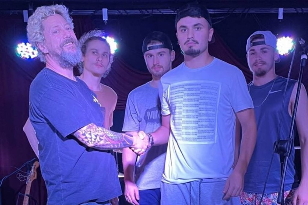 canisso dando a mão para jovem com outros três homens ao fundo - metrópoles