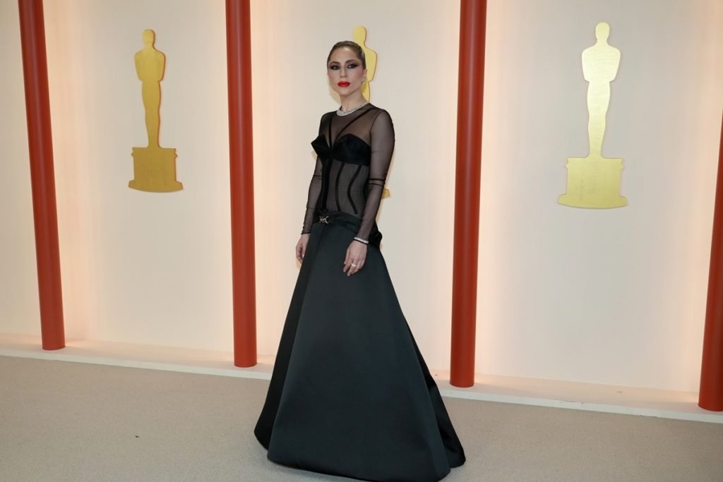 Lady Gaga usando vestido preto longo com transparência, no Oscar 2023 - Metrópoles