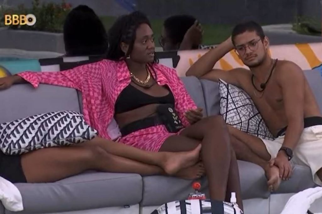 Sarah Aline e Gabriel Santana sentados em sofá na área externa da casa do bbb23 com pernas de marvvila aparecendo do lado direito - metrópoles
