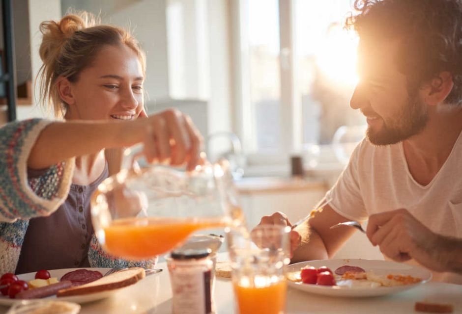 Casal tomando café da manhã com jarra de suco nascer do sol-Metrópoles