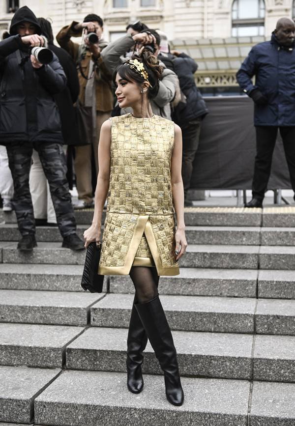 Mulher usa look dourado com tiara e botas pretas - Metrópoles
