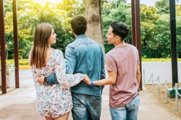 Mulher dá a mão a um homem escondida do namorado - Metrópoles