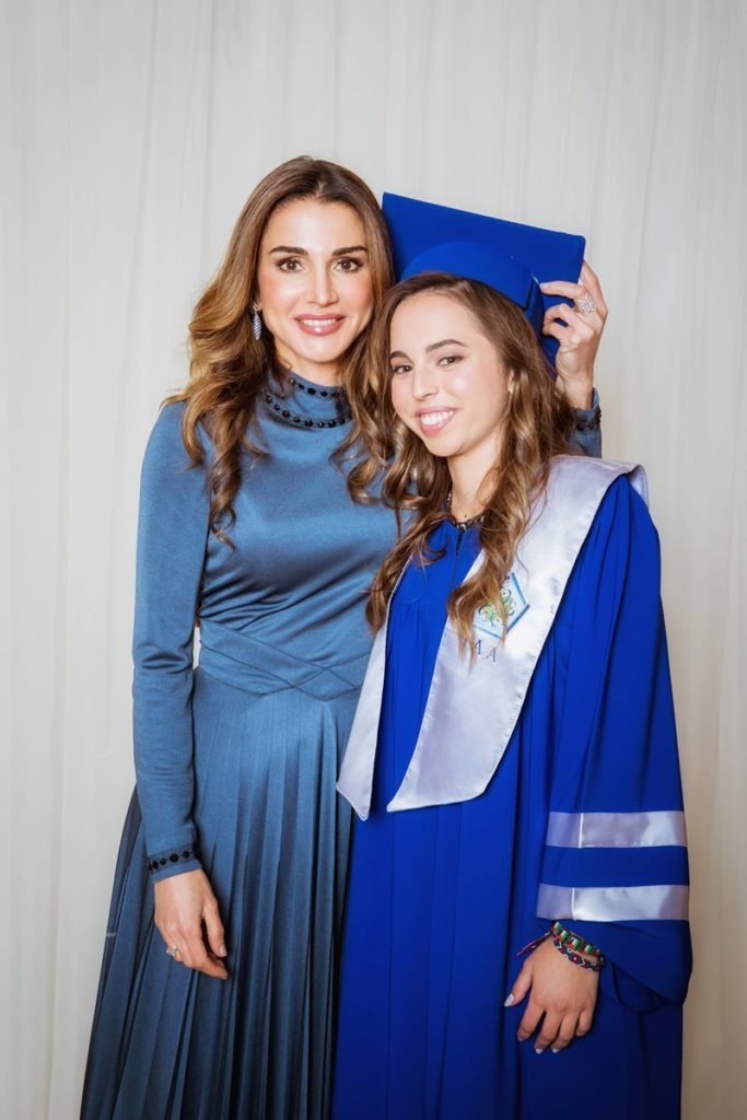 Foto colorida de duas mulheres pardas abraçadas. Uma delas usa beca de formatura - Metrópoles