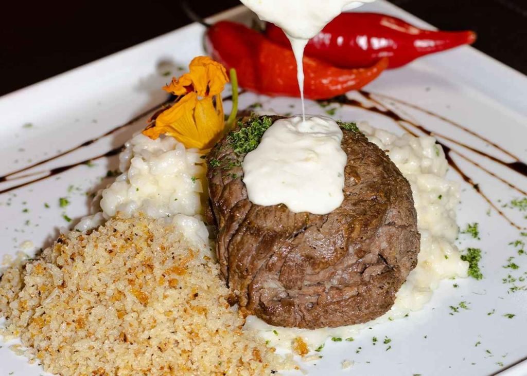 Na foto, um prato branco com comidas nordestinas - Metrópoles