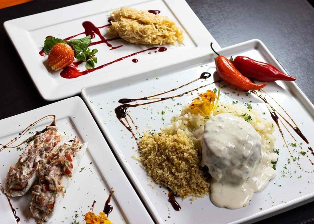 Na foto, um prato branco com comidas nordestinas - Metrópoles
