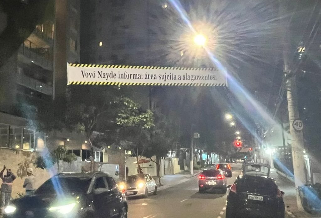 Familiares de vítima instalam faixa de aviso sobre alagamentos em rua
