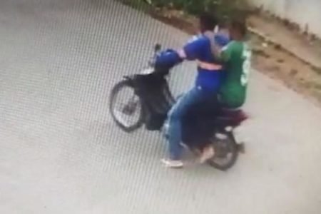 Imagem colorida de câmera de segurança captura o momento em que a dupla de criminosos assalta um homem e leva sua moto após balear policial penal dentro de casa