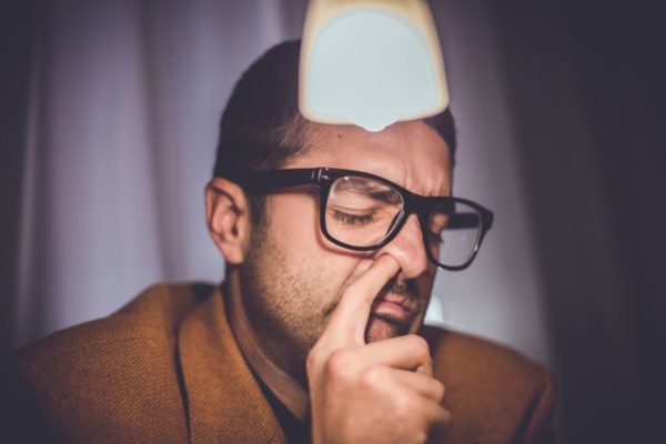 Imagem colorida: homem com o dedo no nariz