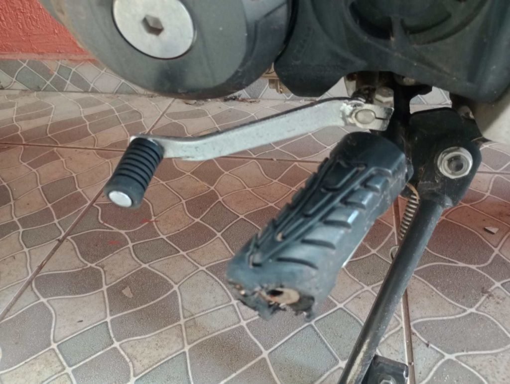 Pedal de moto Honda cinza danificado