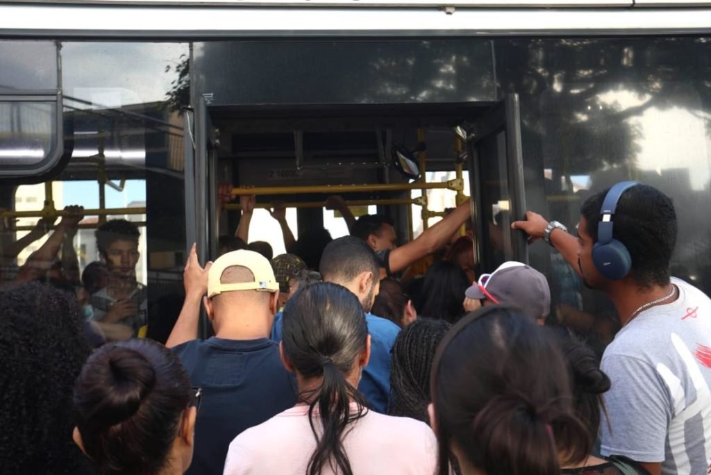 Imagem colorida de pessoas pegando ônibus