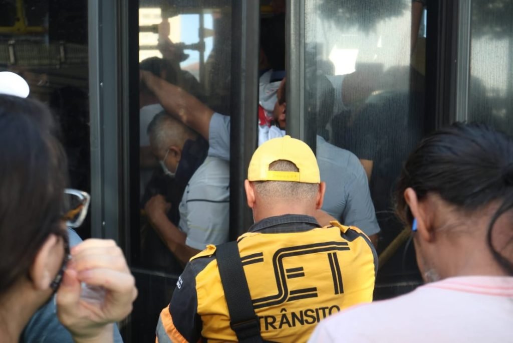 Imagem colorida de pessoas pegando ônibus