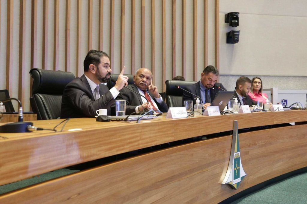 Ex-secretário de Segurança Pública do DF Júlio Danilo na CPI da CLDF fala ao microfone. Presidente da CPI deputado Chico Vigilante (PT) acompanha depoimento