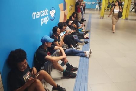 Imagem colorida de pessoas sentadas no chão esperando o fim da greve no Metrô-SP