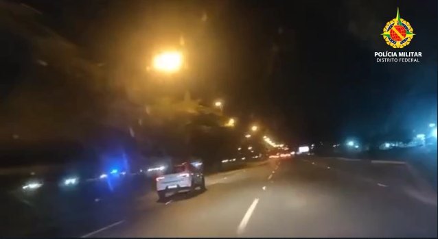 Carro branco circula por via deserta a noite
