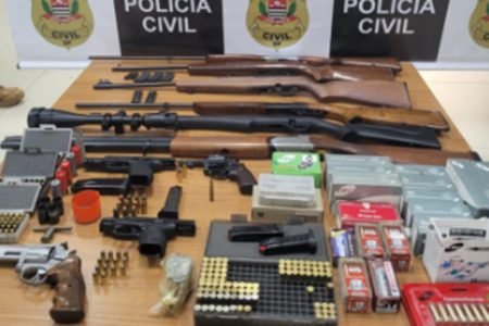 Imagem colorida de armas, cartuchos e dinheiro apreendidos com ladrões em SP