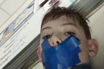 Imagem colorida: menino com a boca tapada por fita adesiva - Metrópoles