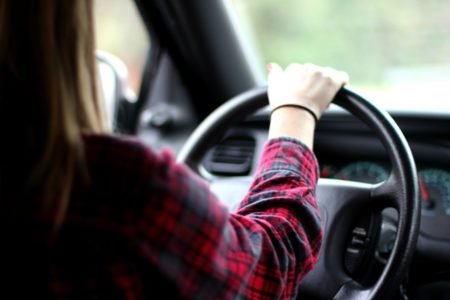 Imagem colorida: mulher de costa com mãos no volante - Metrópoles