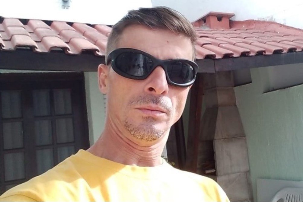 Imagem colorida: homem de óculos de sol e camisa amarela - Metrópoles