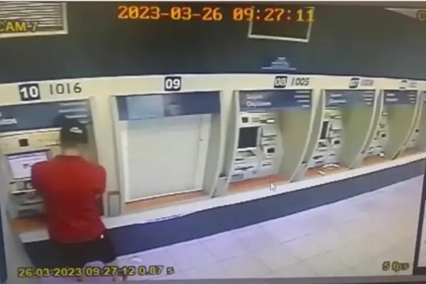 Imagem colorida: homem de costas aplica golpe em caixa eletrônico - Metrópoles