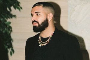 Drake de perfil usando terno preto - Metrópoles