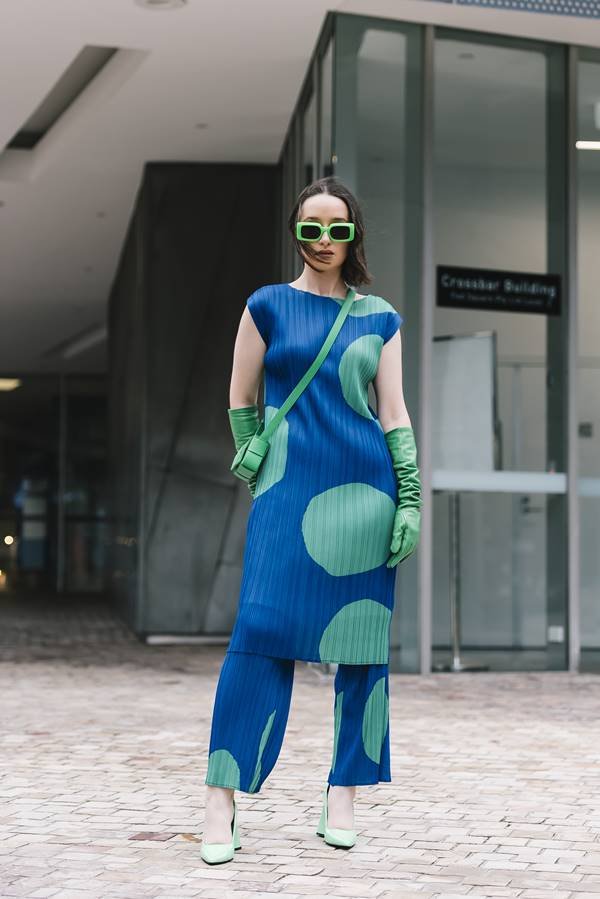 Mulher parada na rua com roupas coloridas - Metrópoles