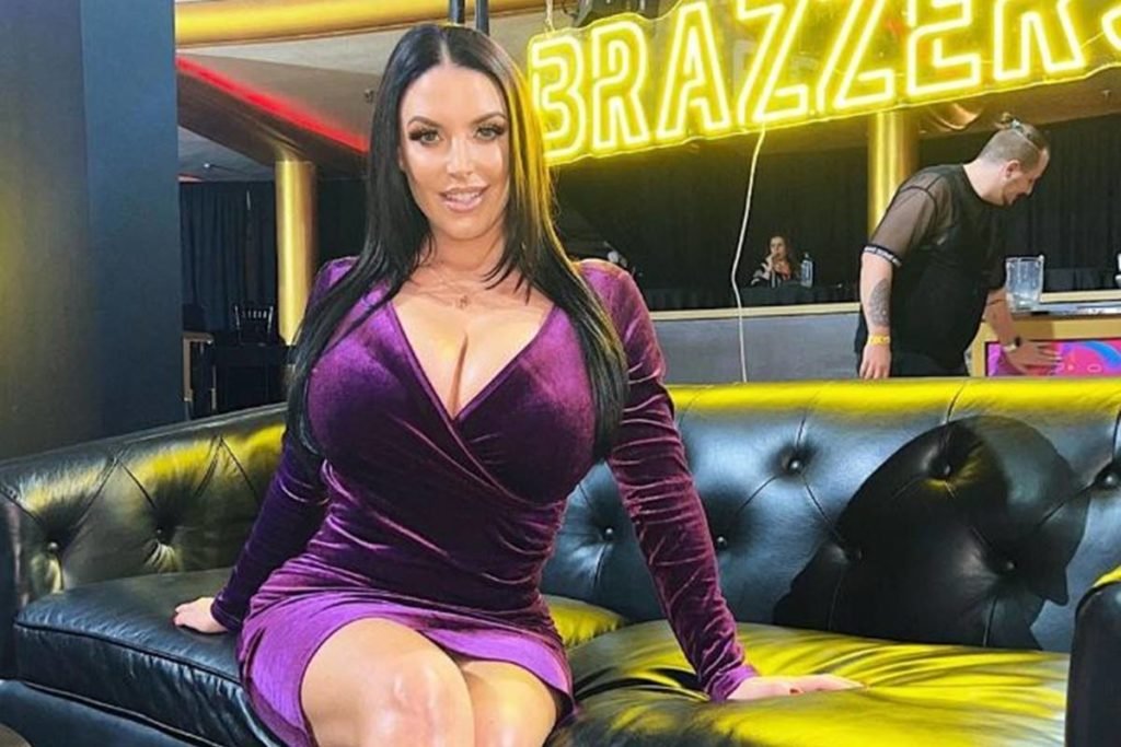 mulher branca de cabelos longos pretos e lisos posa sentada em sofá preto - metrópoles