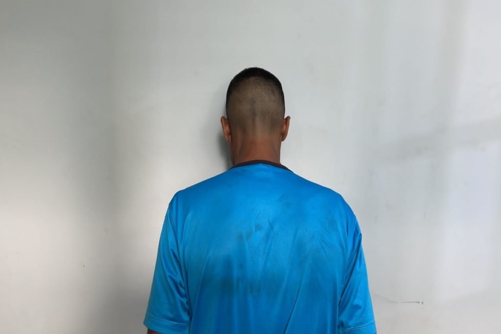 Homem de costas vestindo camisa azul