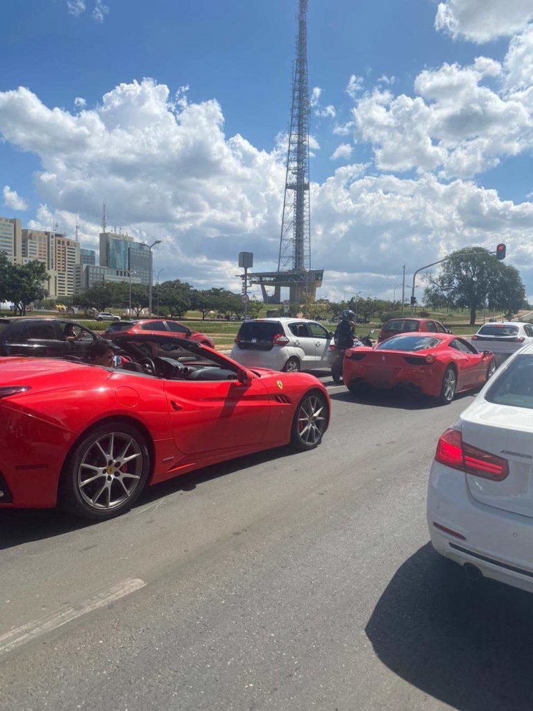 Fila de carros parados em semáforo próximo a Torre de TV