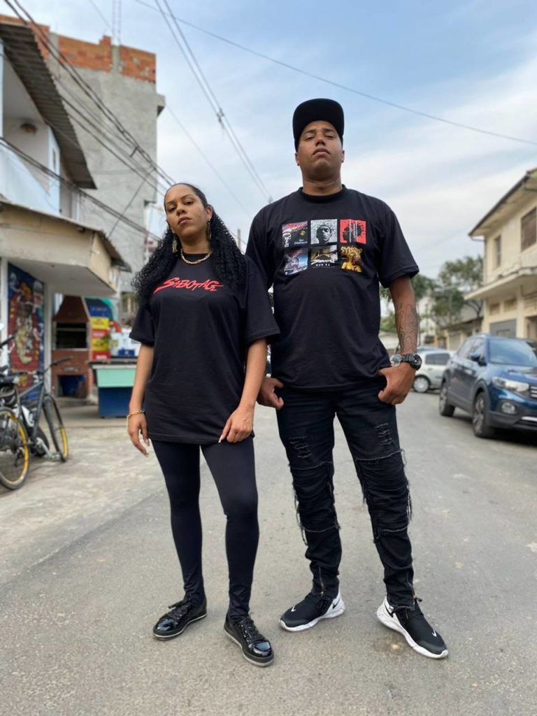 homem e mulher pretos posam serios vestidos em roupas pretas - metrópoles