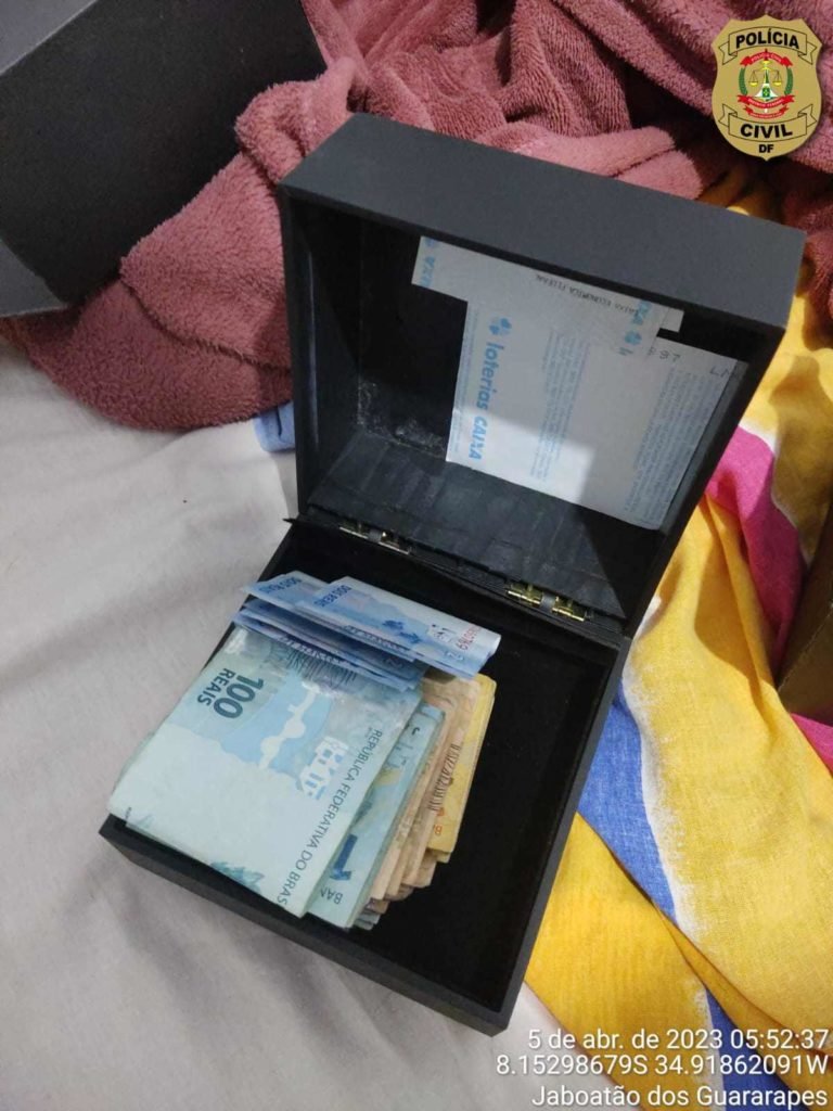 Caixa preta com diversas notas de R$ 100 e 50