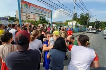 Na foto, várias pessoas em frente a uma creche - Metrópoles