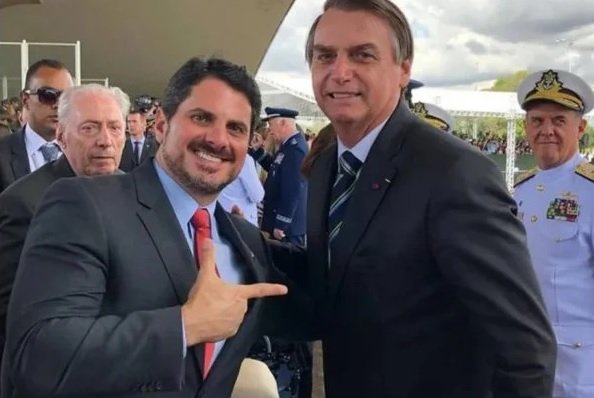 O senador Marcos do Val faz um sinal de arma ao posar ao lado de Jair Bolsonaro