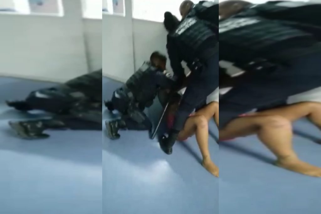 Policiais militares seguram mulher no chão de UPA